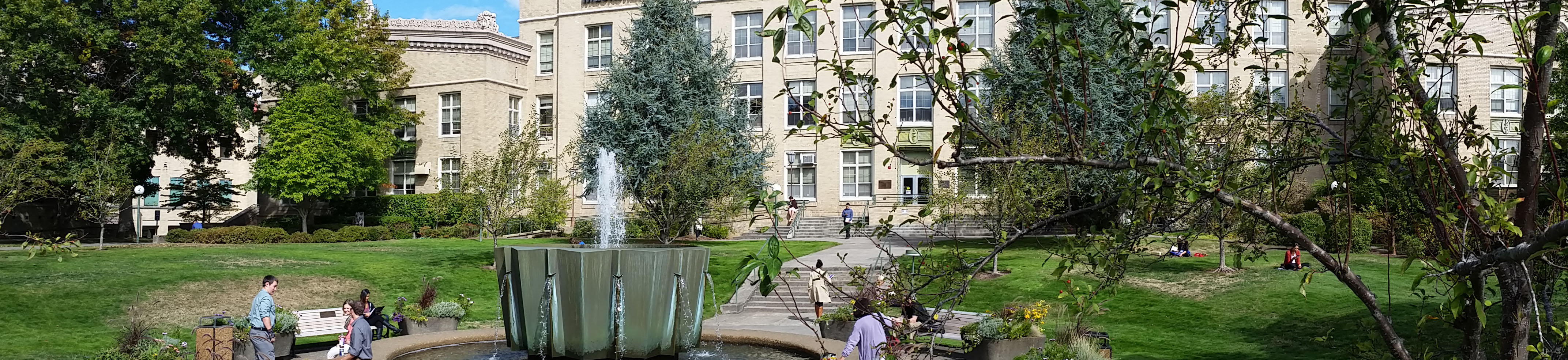 wide view of the Mac Hall fountain in the summer with people enjoying the sun