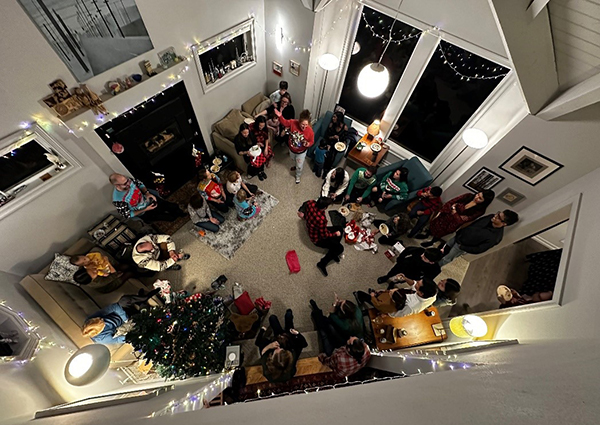 A view looking down from one floor up at a group of people at a party in someone's home.