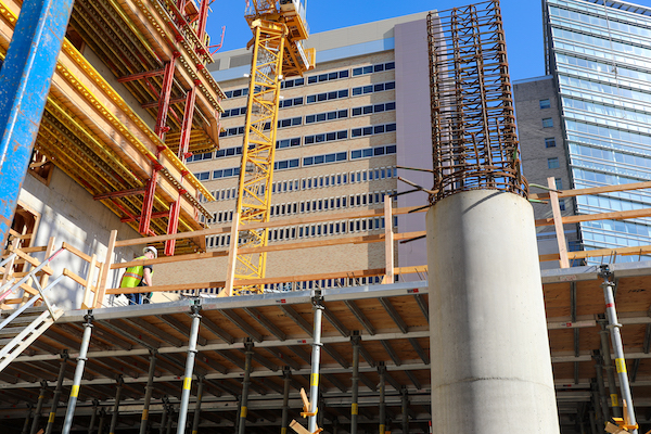 The photo, angled toward the sky, shows the partly constructed new building with OHSU Hospital behind it.
