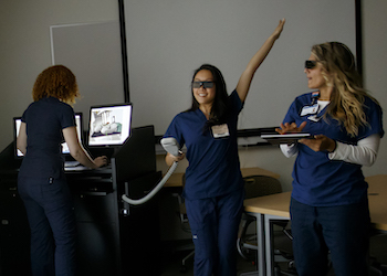 Students in the radiation therapy program laugh together as they practice skills during a simulation.