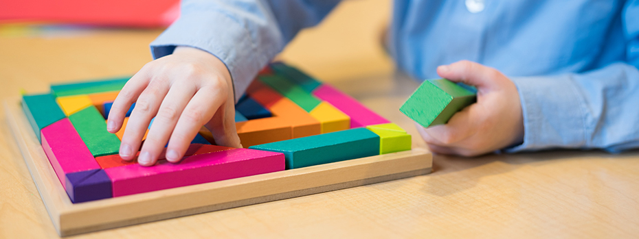 A child plays with a colorful wooden block puzzle at Doernbecher Children’s Hospital.