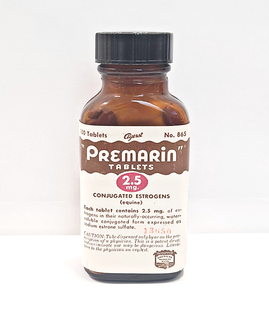 An amber vial with a white label and brown lettering reads "Premarin tablets"