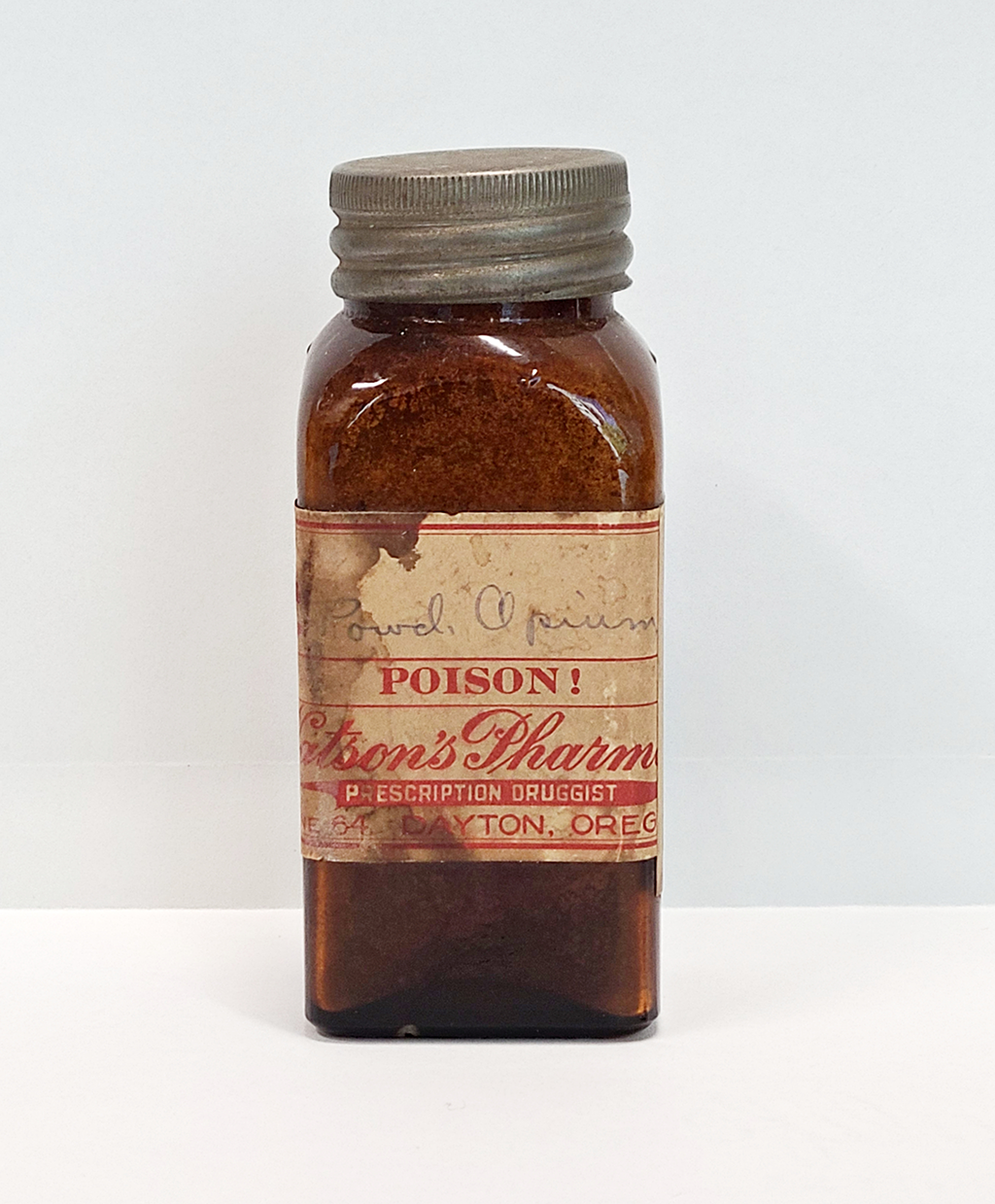 A dark amber vial bears a label marked "Poison!"