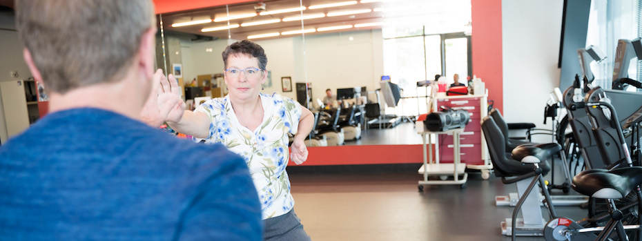 A physical and occupational therapist at OHSU shows another person how to do an exercise at an OHSU rehabilitation facility. 
