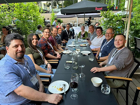 A group of people enjoying a dinner at an outdoor table at a restaurant in Brussels.