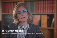 A woman speaking into a camera in front of a bookshelf with text superimposed over the image that reads "Dr. V. Liana Tsikitis, Division Chief of Gastrointestinal and General Surgery, OHSU."