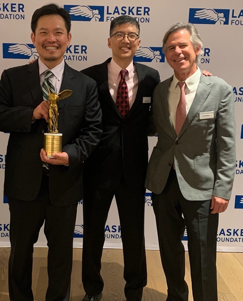 All smiles: Dr Huang holds the Lasker award surrounded by former colleagues