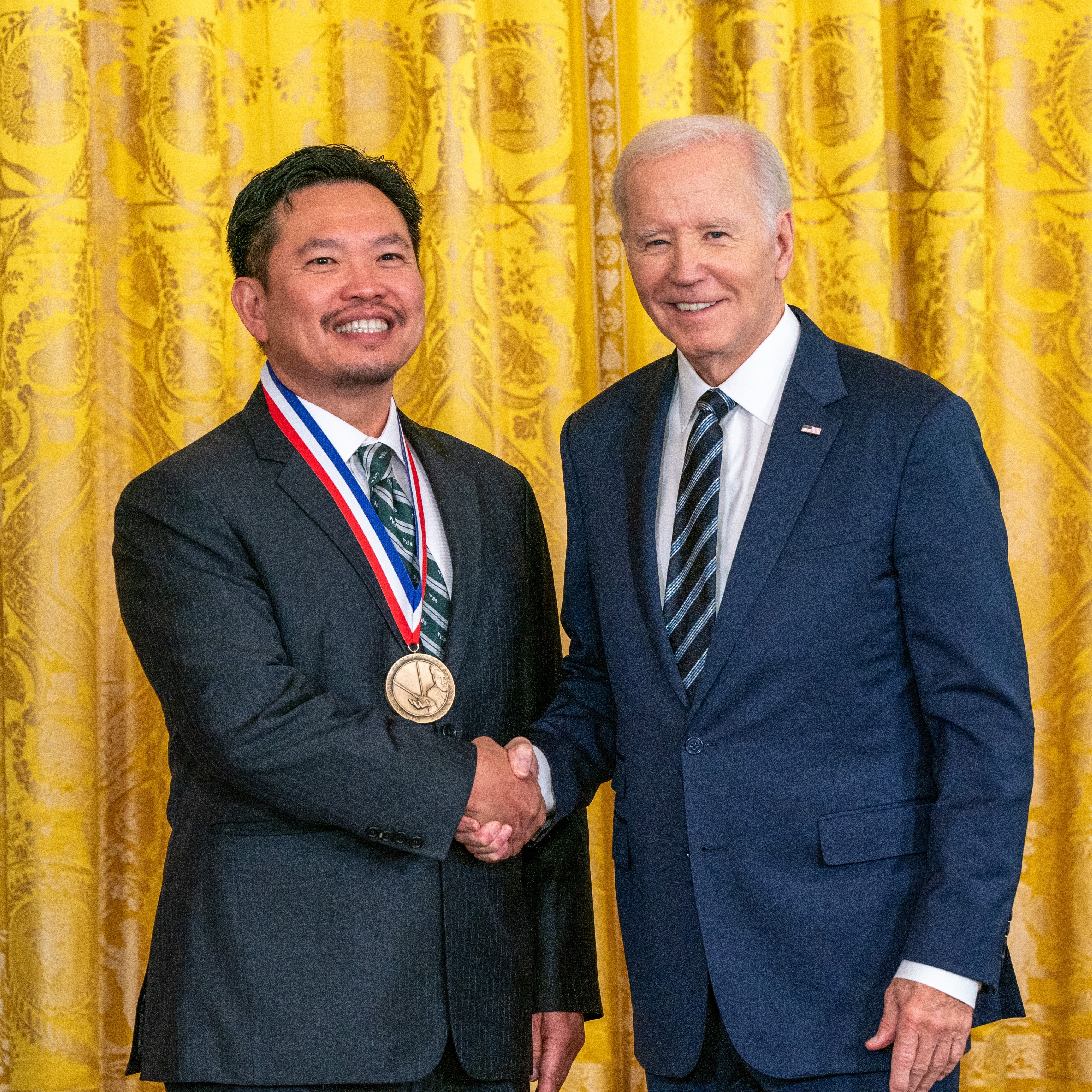 David Huang receiving a medal from President Biden