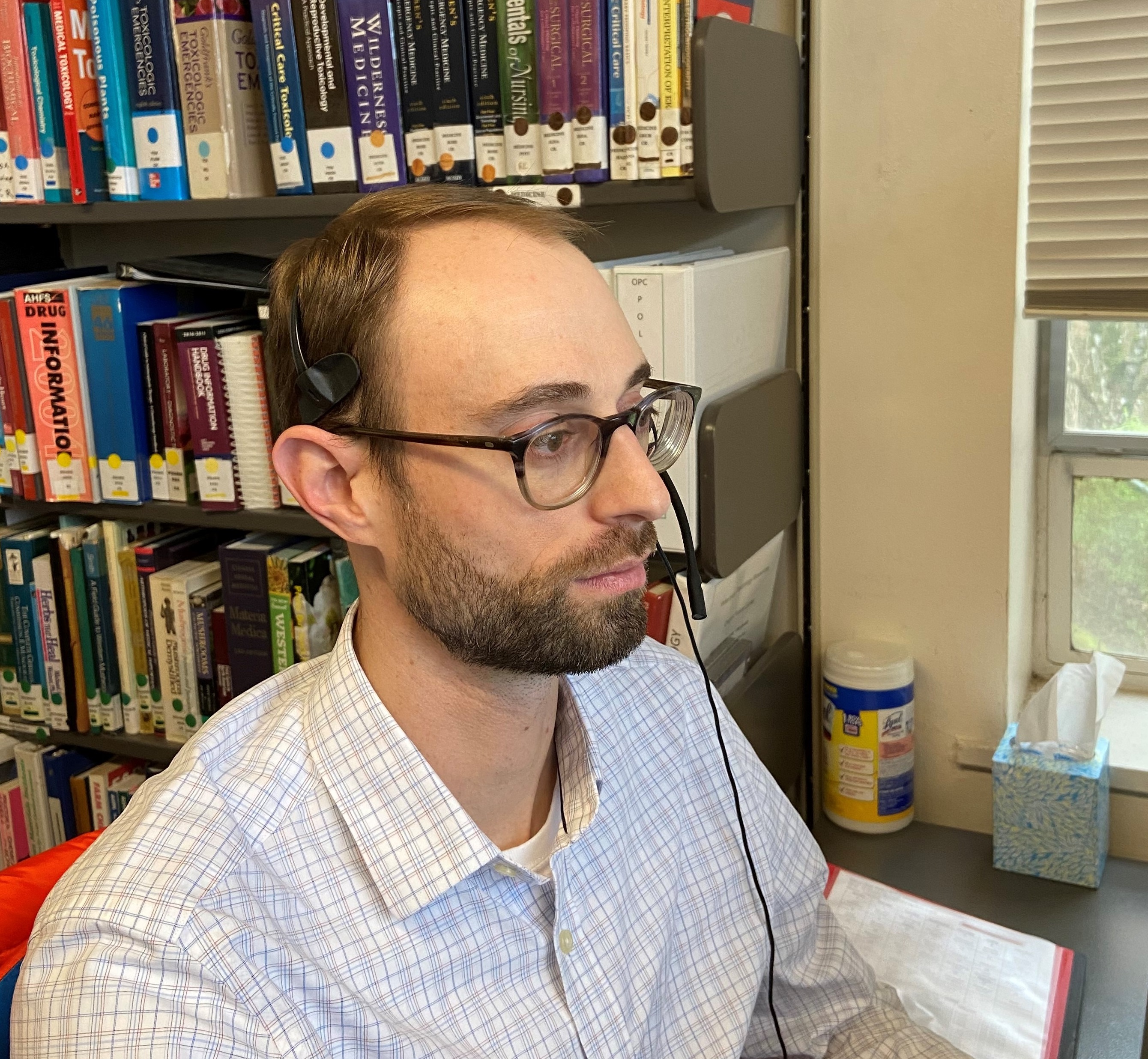 A poison specialist takes a call in in the poison center call room at OHSU