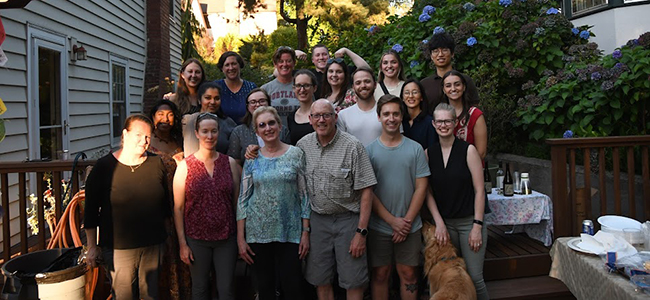 A group photo of the members of the Deborah Lewinsohn Pediatric Research Lab, taken outside on a residential deck.