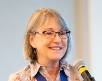 Photo of woman speaking at a microphone