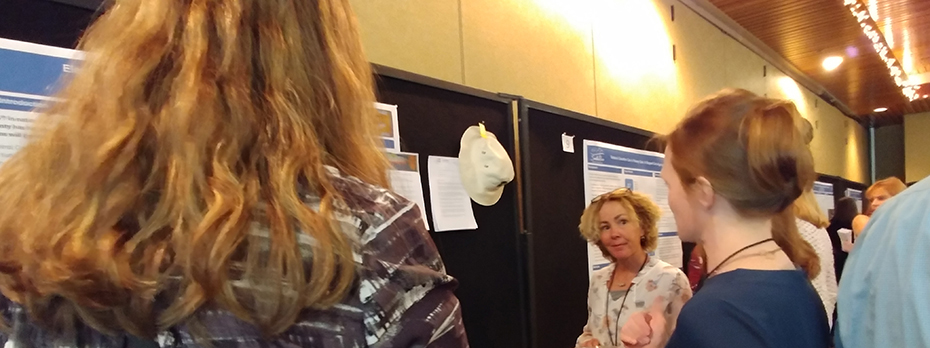 At the grantee conference, Kathleen Bradley looks on as Tammy Wisco presents a poster.