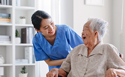 Young Asian woman, nurse, caregiver, carer of nursing home talking with senior Asian woman