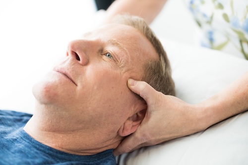 A patient receiving facial rehabilitation support from a specialist with unique training.