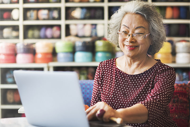 Older Asian woman working on a laptop