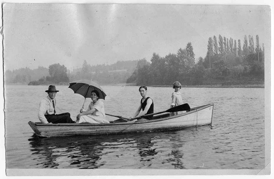 Four people posed in a row boat in Portland.