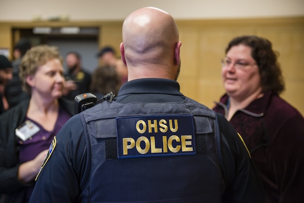 A member of the OHSU police meets with community members.