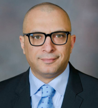 Dr. Raslan headshot - man with blue shirt and tie, clean shaven with glasses
