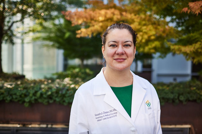 OHSU Oncologist Alexandra Zimmer standing outside wearing her white coat.
