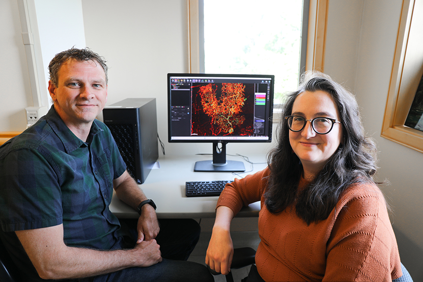 Dr Kevin Wright and Dr Jennifer Jahncke sit in front of a computer monitor displaying an image from their research
