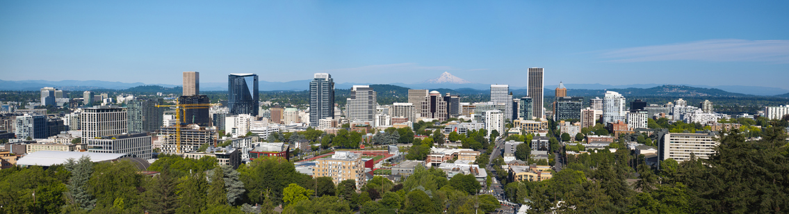 An aerial panorama of downtown Portland, Oregon with Mt Hood in the background.