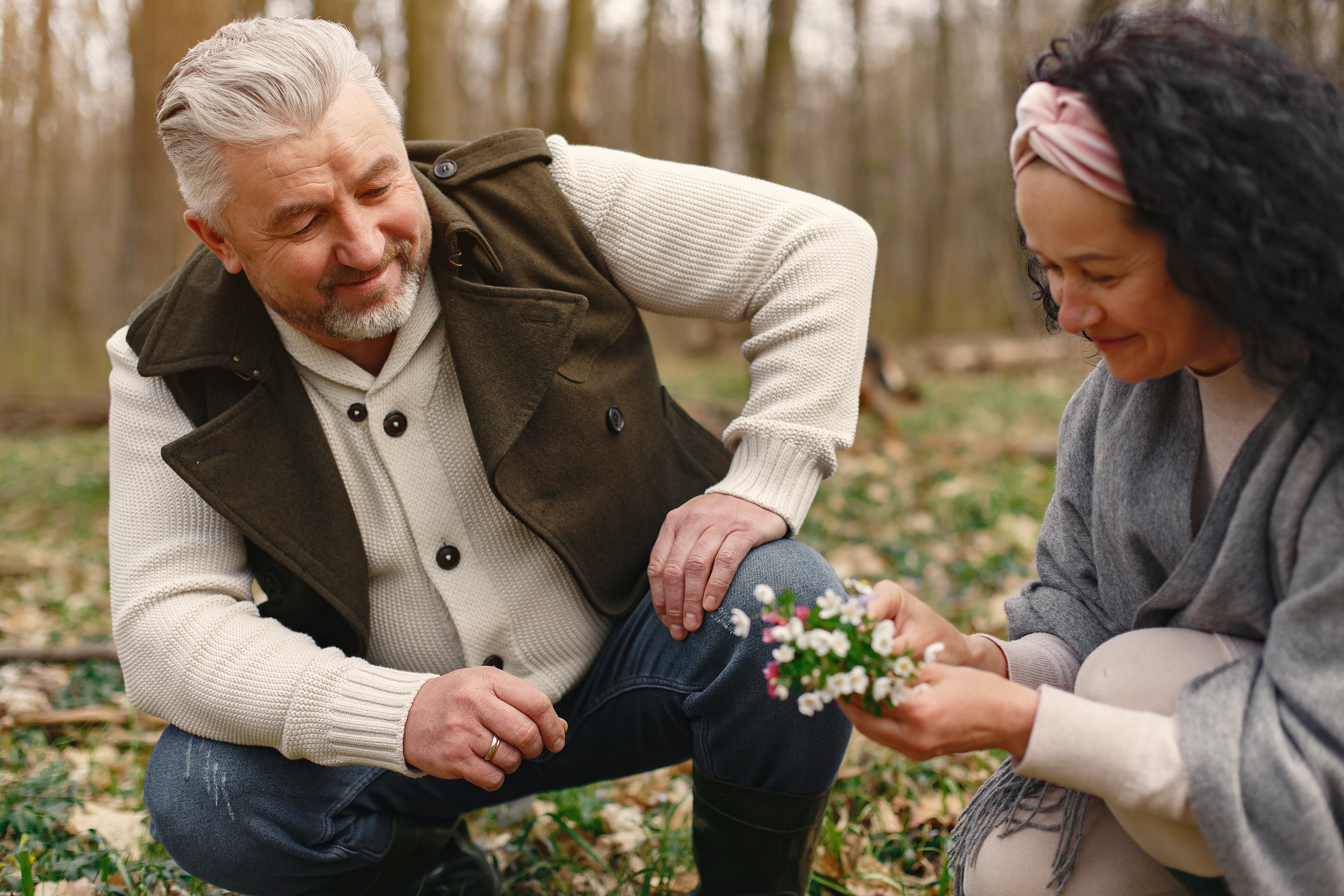 Farmers kneeling down to look at flowers.