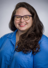 smiling woman with glasses wearing a blue shirt