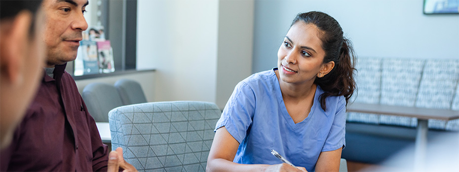 A nutrition student listens and takes notes during a small group discussion.