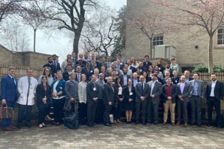 A group of over 60 doctors, trainers, residents and fellows standing on steps outside on OHSU campus in 2023.