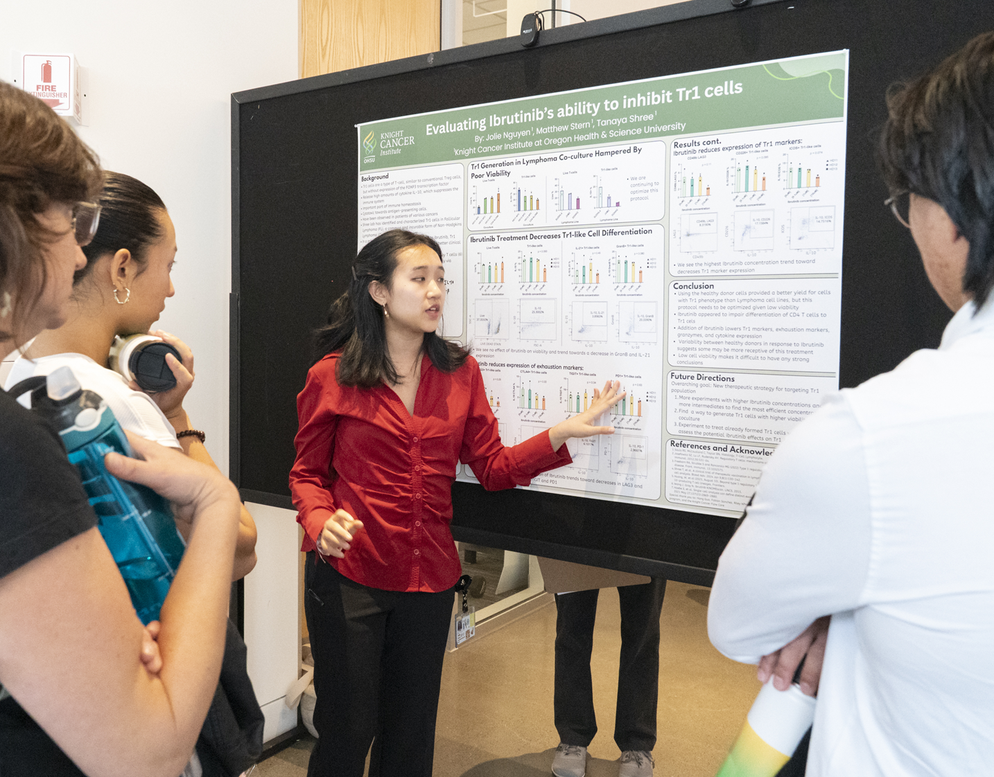 2025 Intern Jolie Nguyen presenting her Research Poster to a group of people