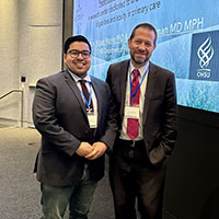 Two men in professional suits smiling