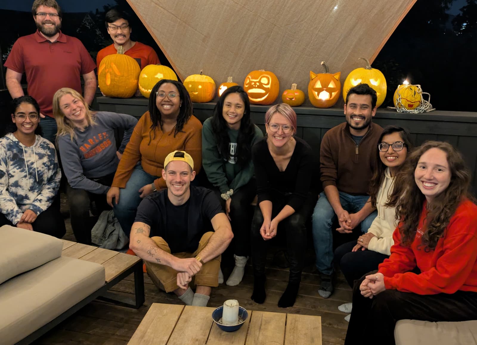 A group of people in front of carved Halloween pumpkins