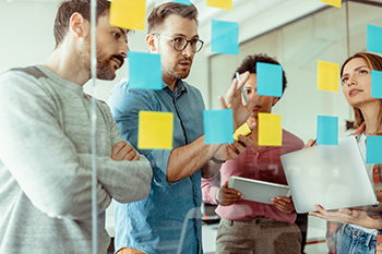 Educators collaborate using sticky notes during a planning session.
