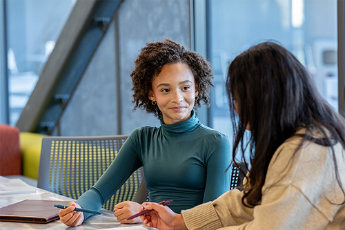 An OHSU student discussing a career in healthcare with a local high school student.
