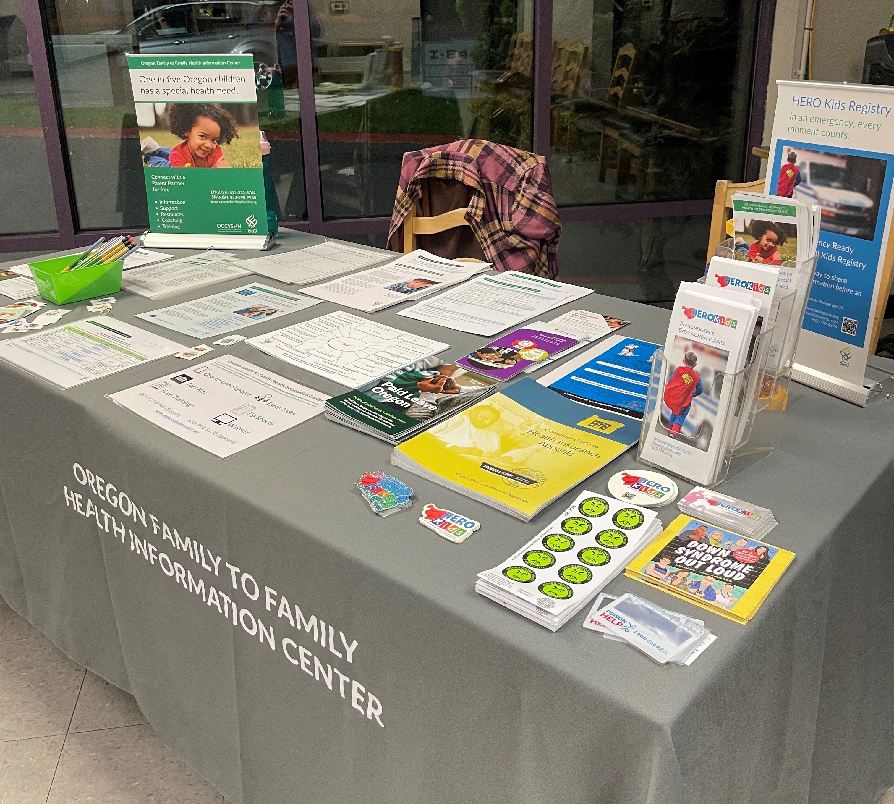 Resource table covered with a grey table cloth and filled with handouts