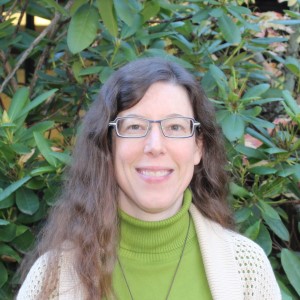 Willi, a middle-aged light-skinned woman with long brown hair and glasses.