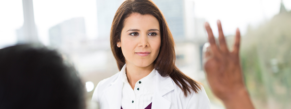 Alt text Dr. Delaram Safarpour guides a patient through hand movement exercises at OHSU