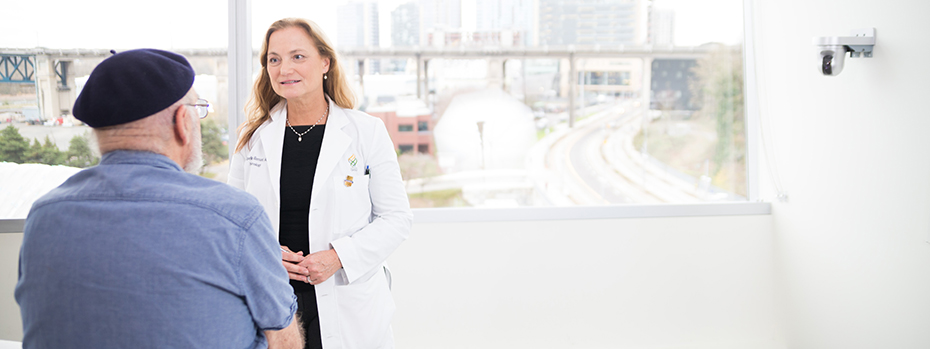 Dr. Jacqueline Bernard talks to a patient in a medical office room.