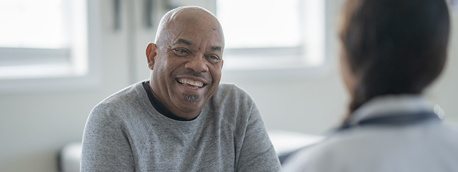 Senior adult man smiles at his doctor during a discussion in a medical office