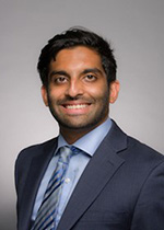 Dr. Avinash Kolli, in a suit jacket and tie, smiles at the camera in a portrait.