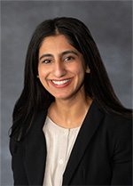 Dr. Mehren Shahid, in a suit jacket and blouse, smiles at the camera in a portrait.