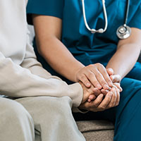 image of physician holding hands with a patient