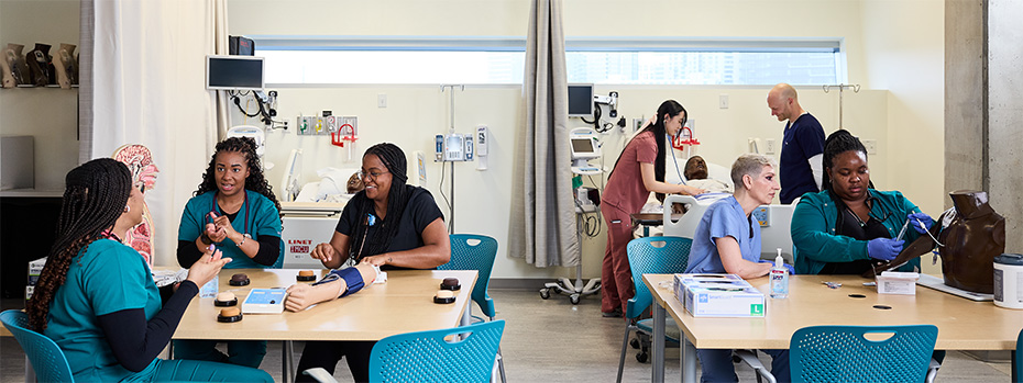 OHSU nursing students practice clinical skills at multiple    simulation stations with manikins throughout the simulation skills lab.