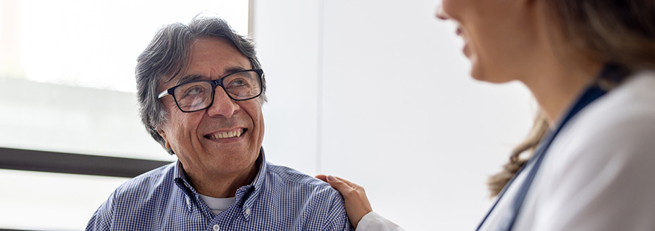 Senior man talks to a doctor in the waiting room of a hospital.