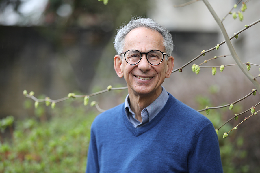 Dr. Stephen Back standing outside smiling with foliage behind him.