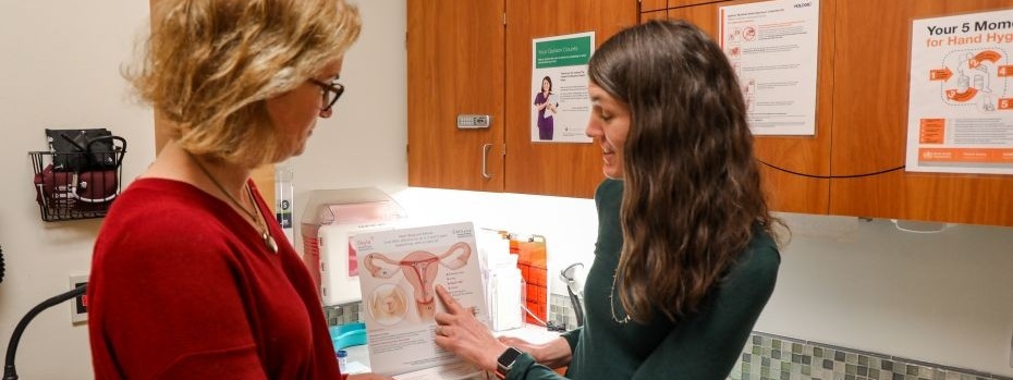 A doctor uses a handout to explain IUD placement.