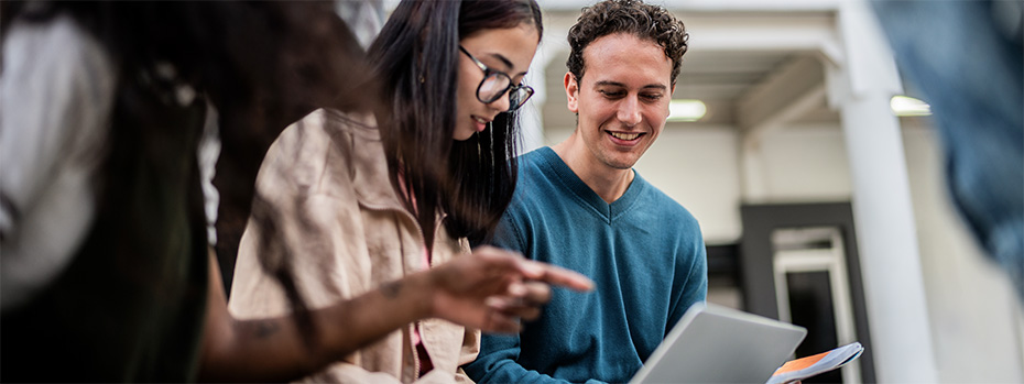 Three OHSU students sit together and review a course syllabus. 