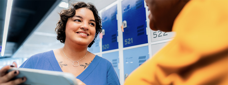 Two OHSU students sit across from each other smiling while reviewing a document.