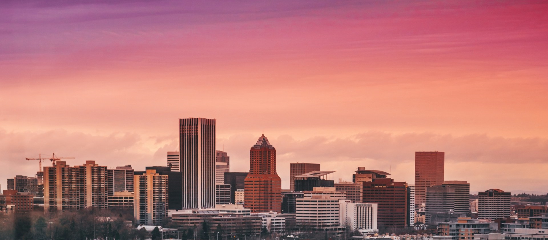 Portland skyline against a purple, pink and orange sky