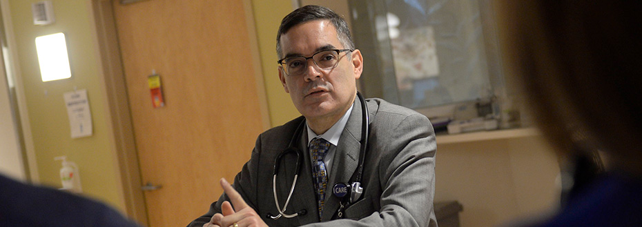 Joaquin Cigarroa, M.D., speaks to cardiovascular medicine staff in a hospital hallway.